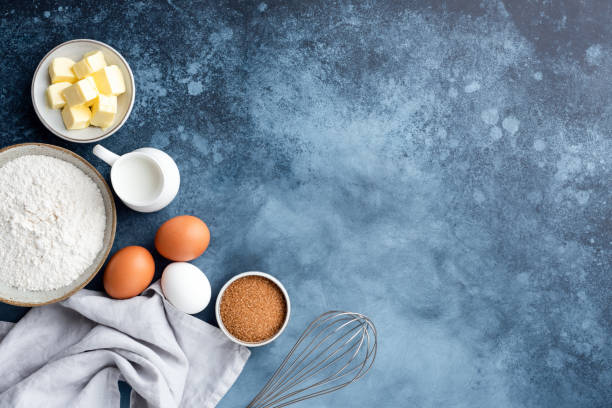 Baking ingredients flour eggs sugar and butter Baking ingredients flour eggs sugar milk and butter on a painted blue background. Top view copy space. Baking concept baking stock pictures, royalty-free photos & images
