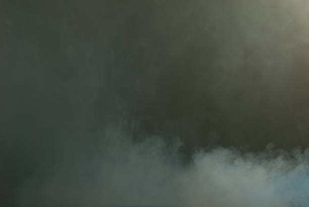 istock White smoke on a black background. Colored smoke with a blue and yellow tinge. The texture of scattered smoke. Blank for design. Layout for collages. 1254762772