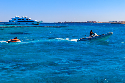 Hurghada, Egypt - December 7, 2018: Happy tourists having fun riding inflatable boat at the Red sea