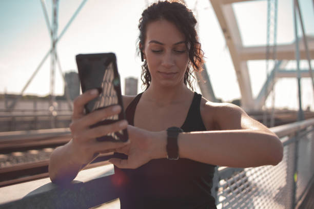 istock Fitness woman using smart phone and smart watch 1254763567