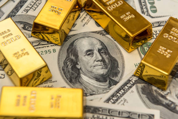 istock gold bars bullions lying on 100 dollar bills 1254764303