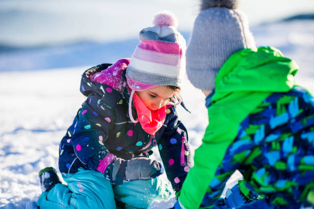 istock Happy kids enjoying winter snow 1254764456