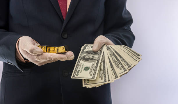 Business man hold dollar and gold bar in medical gloves for safety Business man hold dollar and gold bar in medical gloves for safety. crisis covid19 gold ira custodians stock pictures, royalty-free photos & images