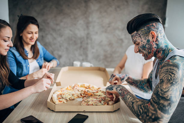 istock Group of friends eating pizza 1254765050