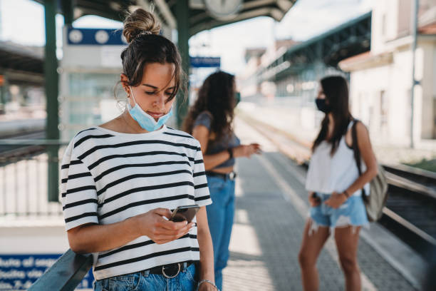 istock Three people waiting for a train at the railroad station 1254765929