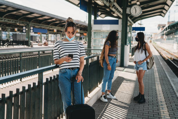 istock Three people waiting for a train at the railroad station 1254765933