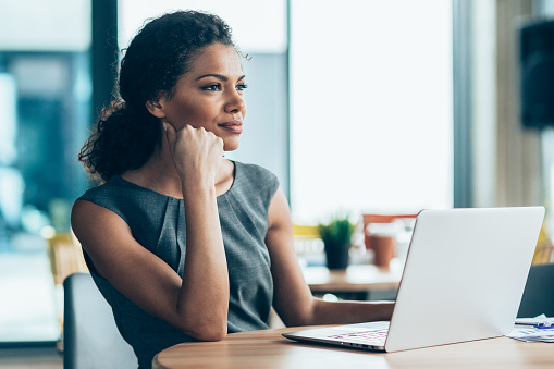 Portrait of a modern and beautiful afro-american businesswoman using laptop