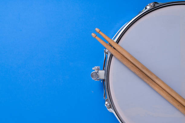 istock Drum stick and drum on blue table background, top view, music concept 1254767468