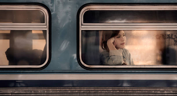 istock young asian woman looking through the train window. 1254769608