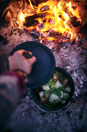 Cropped shot of a man cooking traditional South African food by campfire outdoors