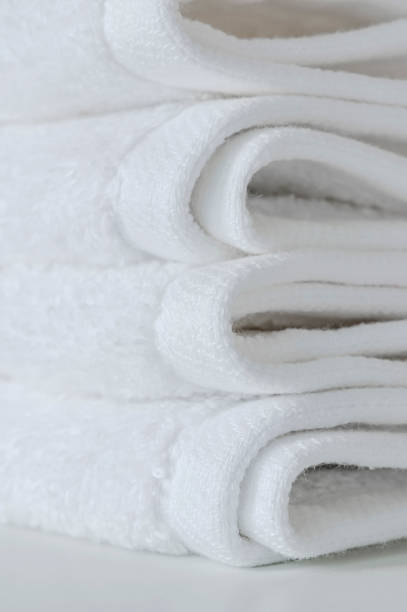 istock Stack of folded white towels on the table, closeup view, vertical view. 1254772664