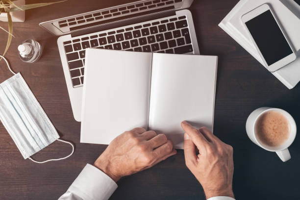 istock Top view of businessman hands holding blank notebook mock up 1254773022