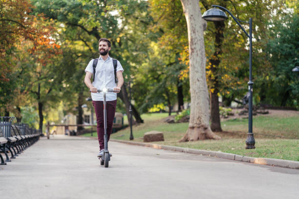 istock Man passing through the park with his e-scooter 1254776029
