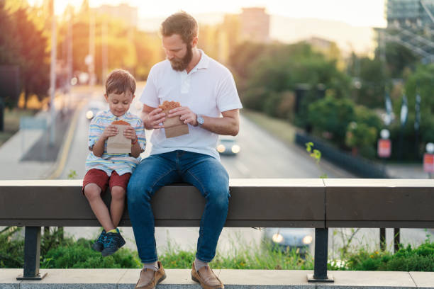 istock Father and son eating burgers 1254776033