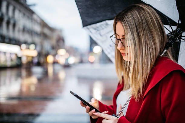 istock Woman texting in the rain 1254777803