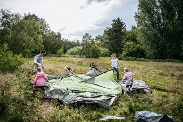 istock Family with three children setting up tent for camping 1254778002