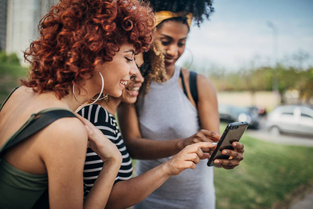istock Young women using smart phone outdoors in the city 1254779269