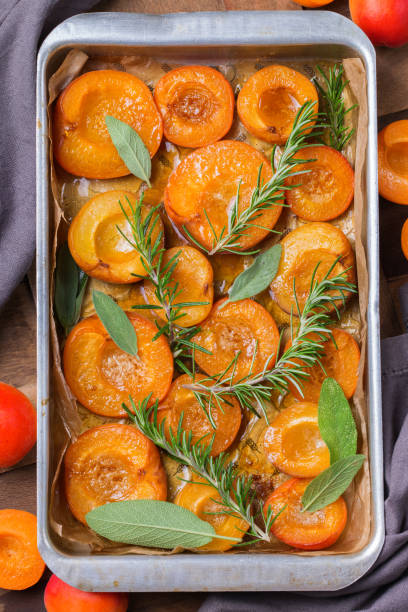 albicocche al forno con miele, salvia e foglie di rosmarino - dessert grilled peaches peach foto e immagini stock