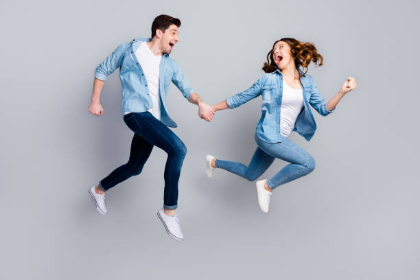 istock Full size photo of cheerful funky students spouses enjoy spring weekend rest jump hold hand run moving wear casual style outfit gumshoes isolated over gray color background 1254782340