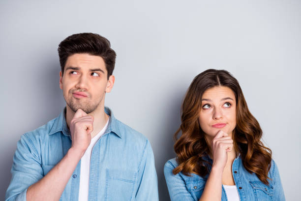 istock Photo two people lady handsome guy couple look up empty space doubtful situation who is right wrong wear casual denim shirts outfit clothes isolated grey color background 1254782358