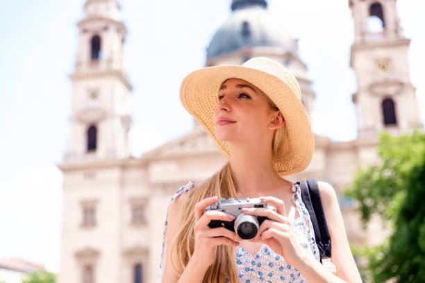 istock Attractive young woman taking pictures with camera while on sightseeing 1254785845