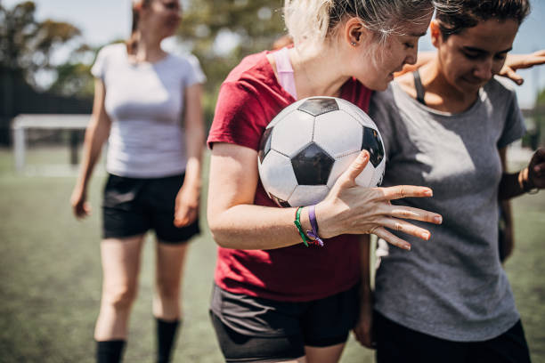Women enjoying time together on soccer field Group of women, female soccer players, enjoying time together outdoors on soccer field. football player girlfriend stock pictures, royalty-free photos & images