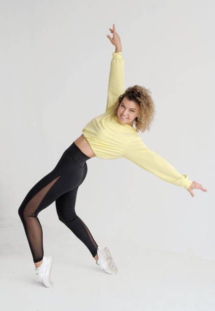 istock Smiling curly hair woman in dance studio 1254786461