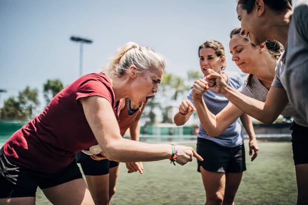 Women celebrating victory on soccer playing field Group of women, female soccer players, celebrating victory outdoors on soccer field. football player girlfriend stock pictures, royalty-free photos & images
