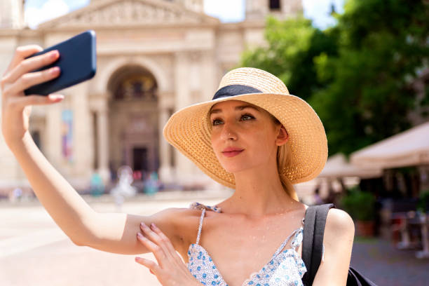 istock Attractive young woman making self portrait while walking in the city 1254786661