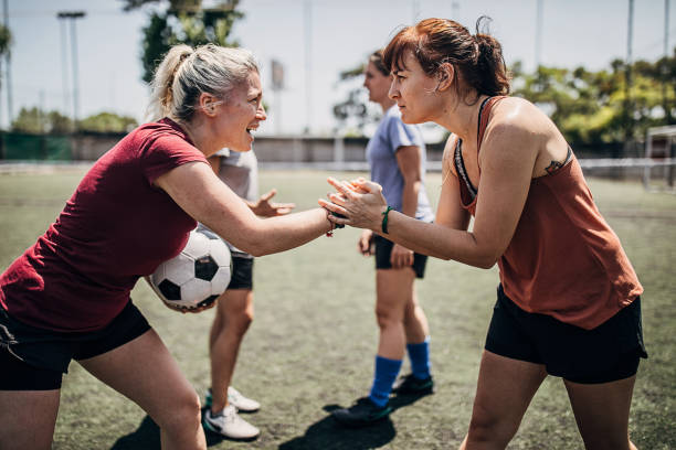 istock Two women handshake on a soccer field 1254786919