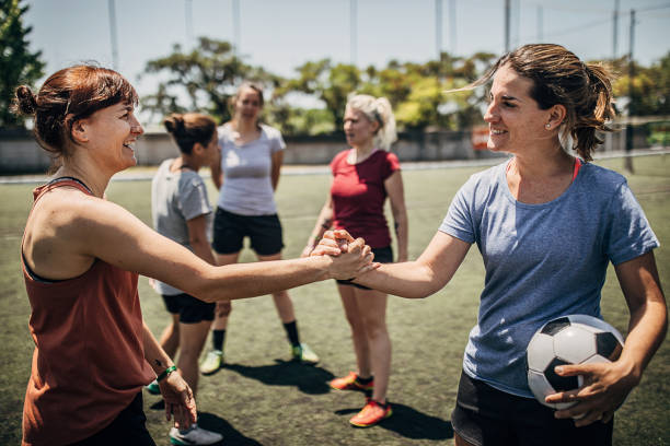 istock Two women handshake on a soccer field 1254786951