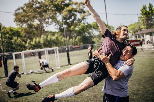 istock Two men celebrating victory on soccer field 1254787105