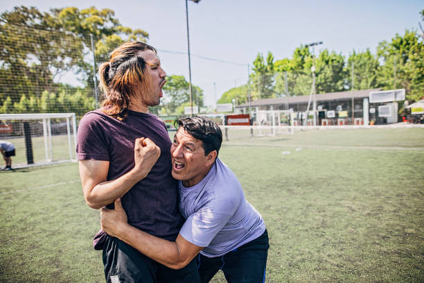 istock Two men celebrating victory on soccer field 1254787139