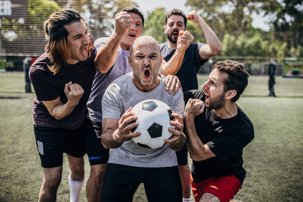 istock Men celebrating victory outdoors on soccer field 1254788061