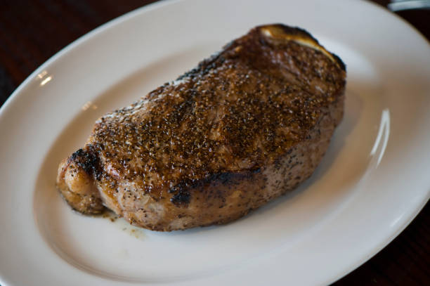 steaks. steaks de bœuf angus nourris à l’herbe de catégorie a. filet, filet mignon, bande new-yorkaise, os en côte-oeil grillé pour un milieu parfait rare sur le gril extérieur au feu de bois. classique américaine steakhouse entrée préférée. - strip steak steak sirloin steak rib eye steak photos et images de collection