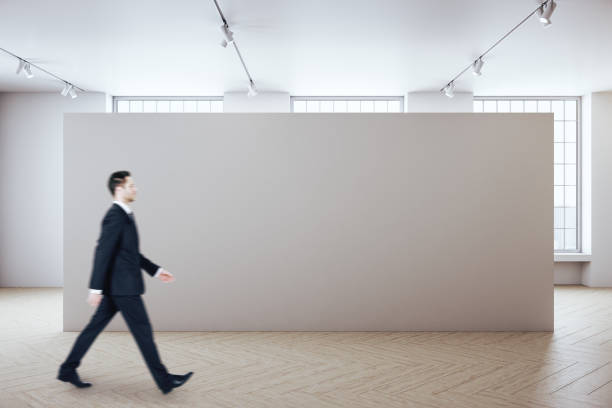 istock Businessman walking in gallery room 1254790500