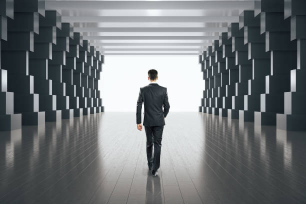 istock Businessman walking in minimalistic concrete tunnel interior. 1254790552