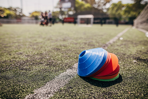 Multi-colored cone markers for football training on soccer field.