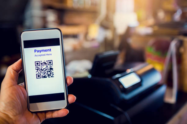istock Scanning QR code payment with blurry cashier machine at counter service in coffee shop. 1254792232