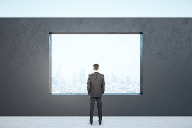 istock Businessman standing in empty interior with megapolis city view 1254792624