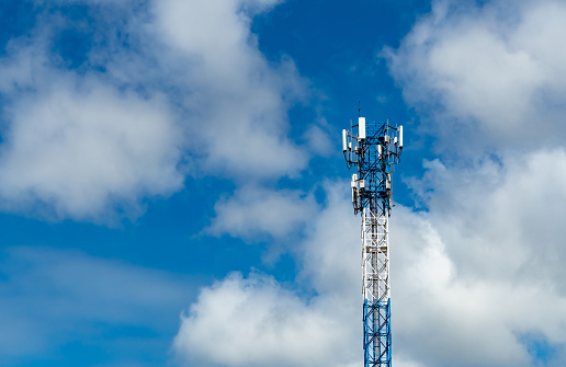 Telecommunication tower with blue sky and white clouds. Antenna on blue sky. Radio and satellite pole. Communication technology. Telecommunication industry. Mobile or telecom 4g network. Technology