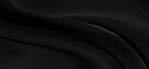 istock Black gray satin dark fabric texture luxurious shiny that is abstract silk cloth panorama background with patterns soft waves blur beautiful. 1254796035