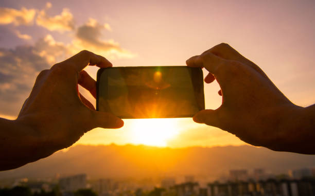 istock Taking a photo by mobile phone at city sunset 1254796431