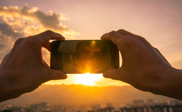istock Taking a photo by mobile phone at city sunset 1254796456