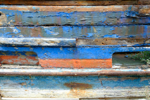 Old damaged paint on a boot stranded in port