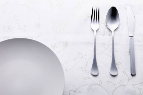 Black table set with plates, cutlery, napkins, and glasses horizontal shot