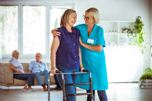istock Cheerful nurse helping senior woman to use walking frame 1254798038