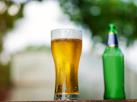 A glass of icy refreshing light beer on a summer background