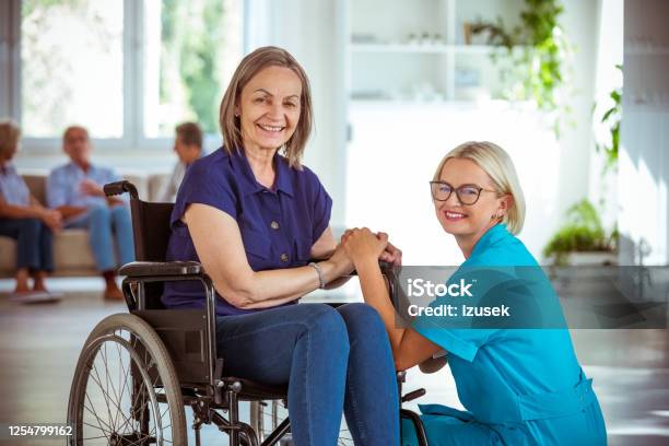 Cheerful Nurse Supporting Senior Woman Stock Photo - Download Image Now - 70-79 Years, A Helping Hand, Adult
