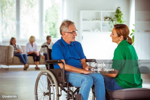 Female Social Worker Supporting Senior Man Stock Photo - Download Image Now - 70-79 Years, A Helping Hand, Adult